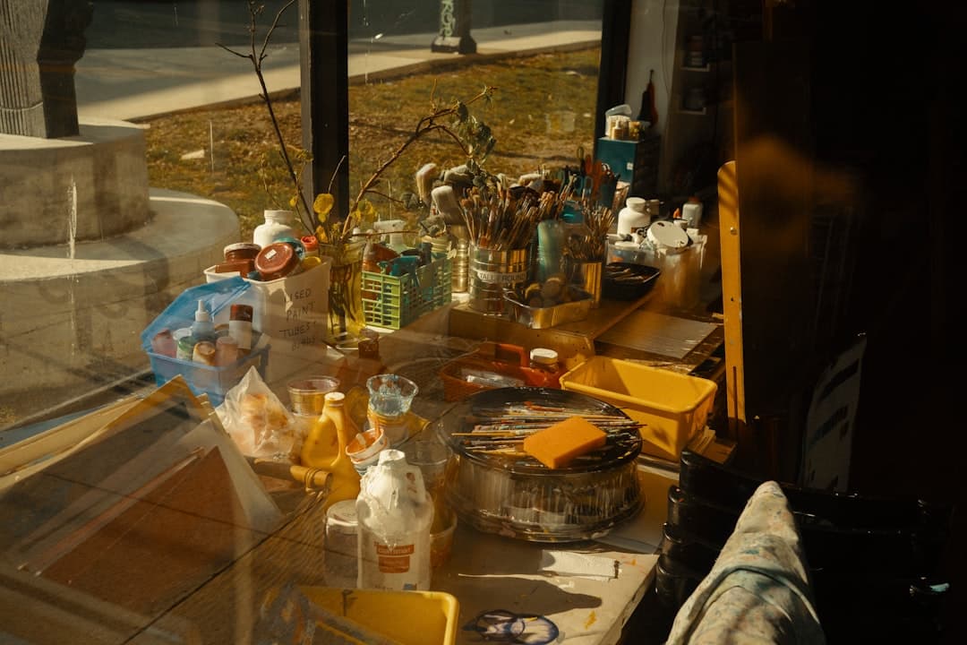 Konstmaterial på en sollysblänkt arbetsbänk i studion